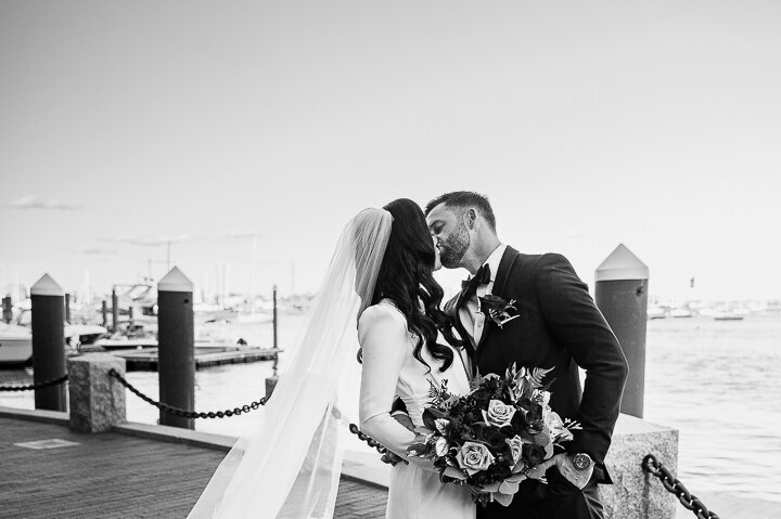 bride and groom kissing near the Boston harbor