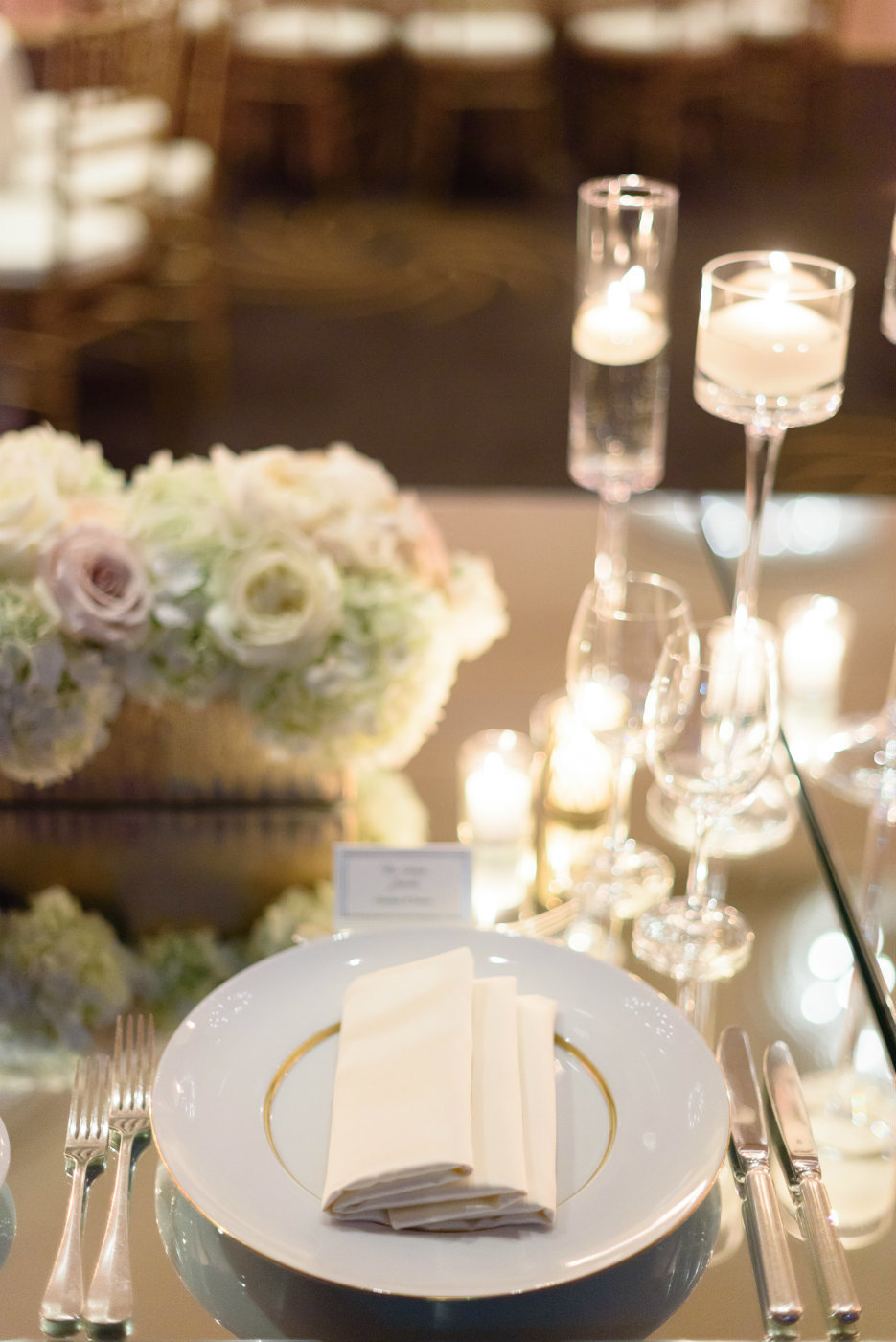 Simple and elegant place setting becomes striking on a mirrored table for this Seattle Four Seasons wedding.