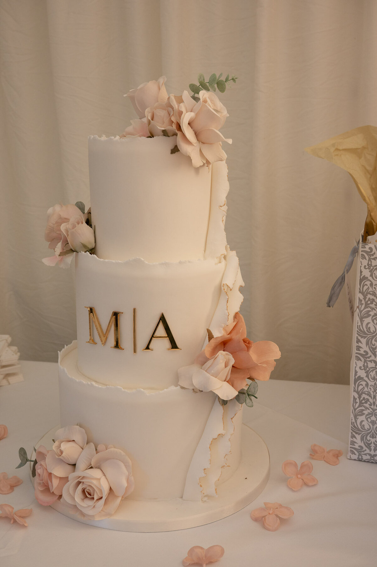Wedding cake with initials “MIA” in blush pink floral design – Manchester wedding detail photo.