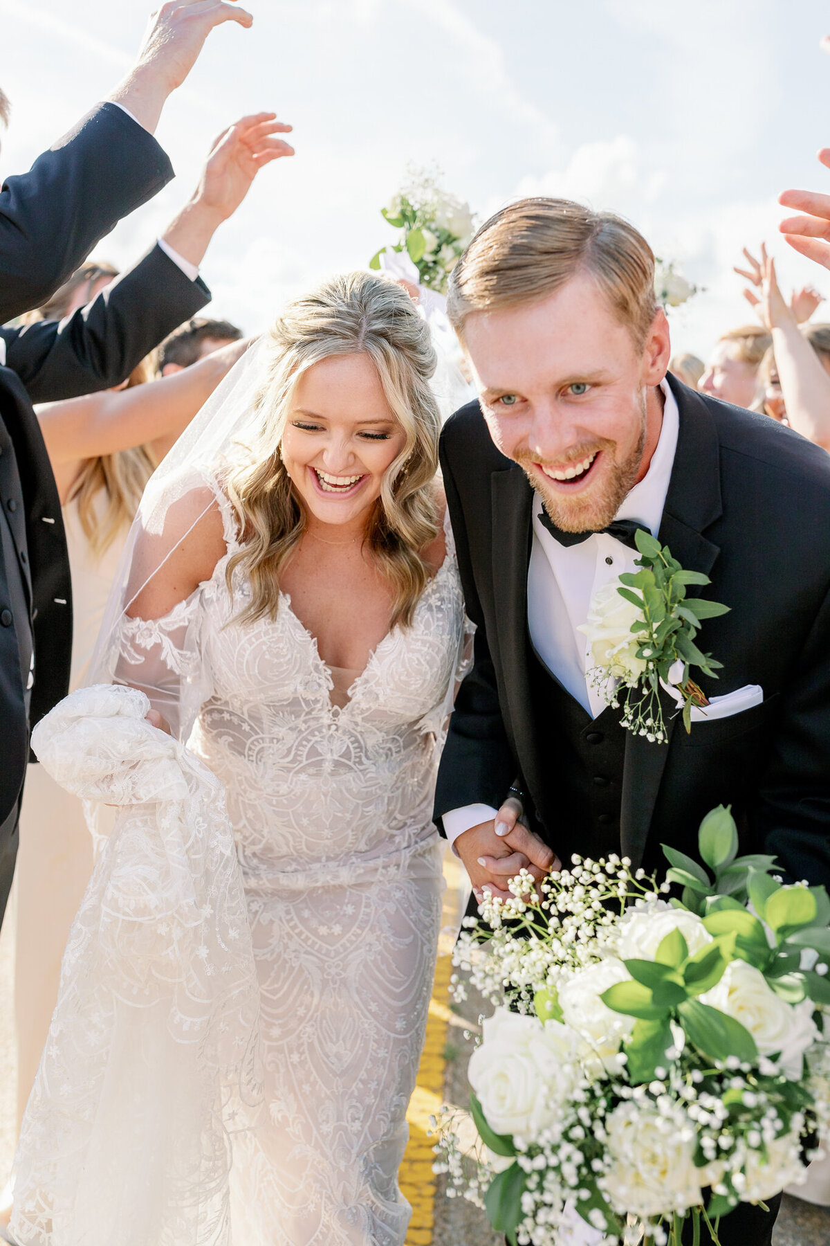 Joyful newlywed couple photographed with their wedding party