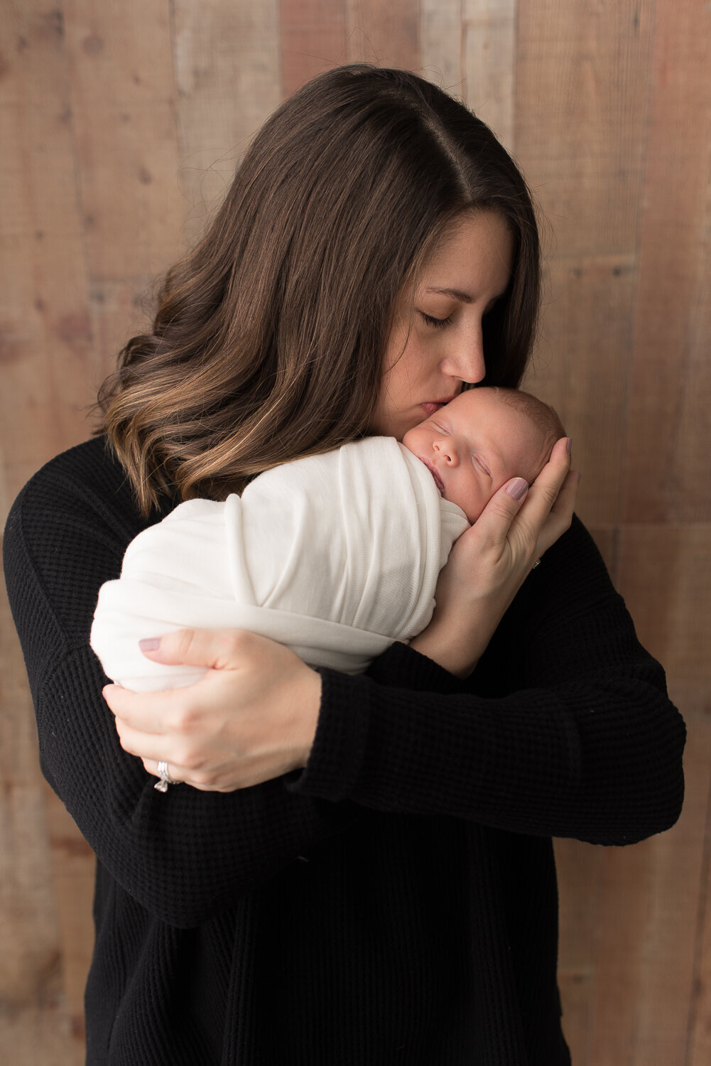 Mother kissing her new baby boy wrapped in white |Sharon Leger Photography | Canton, CT Newborn & Family Photographer