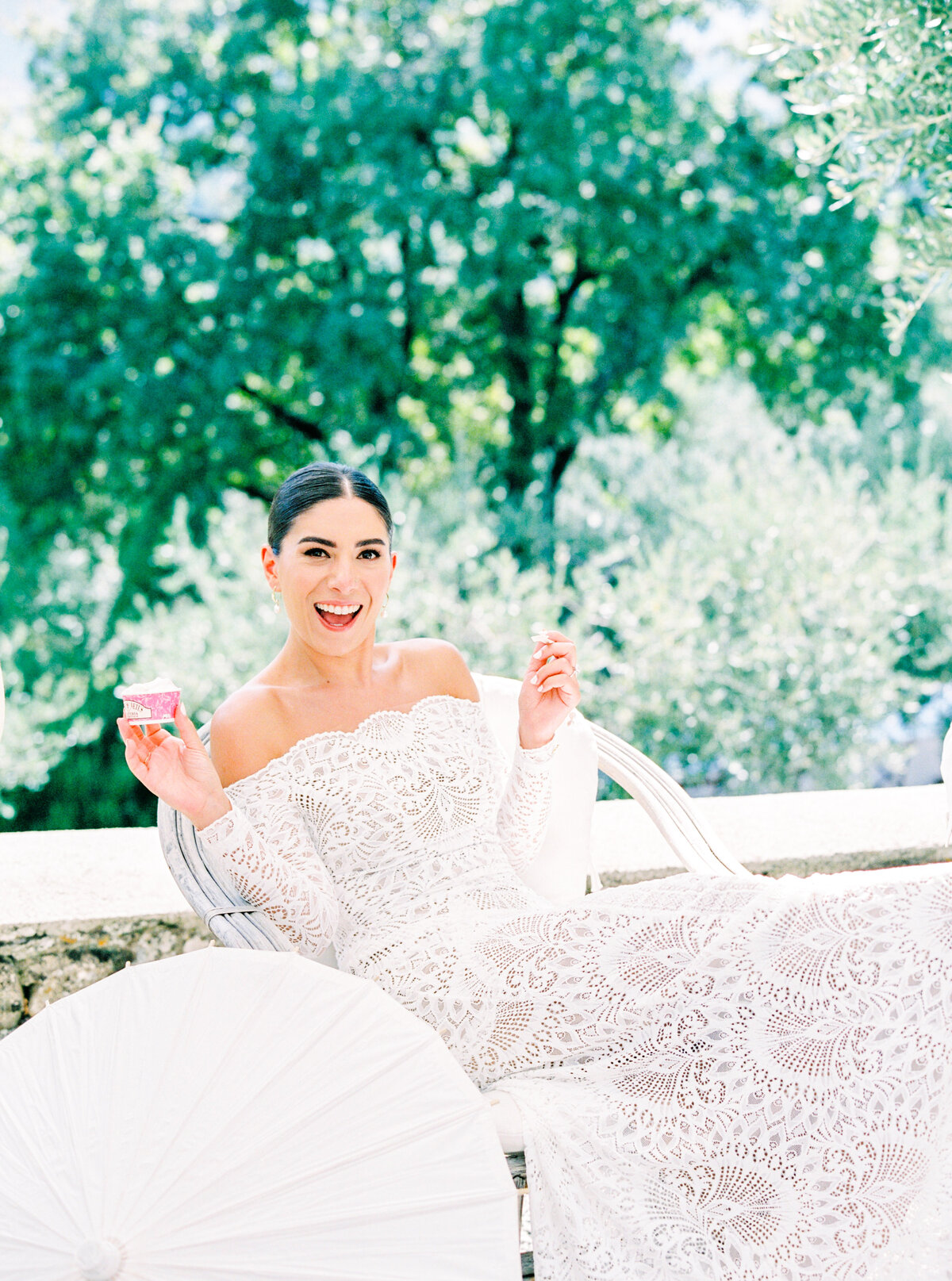 Film photograph of Bride in all lace gown eating gelato at her wedding photographed by Italy wedding photographer at Villa Montanare Tuscany wedding