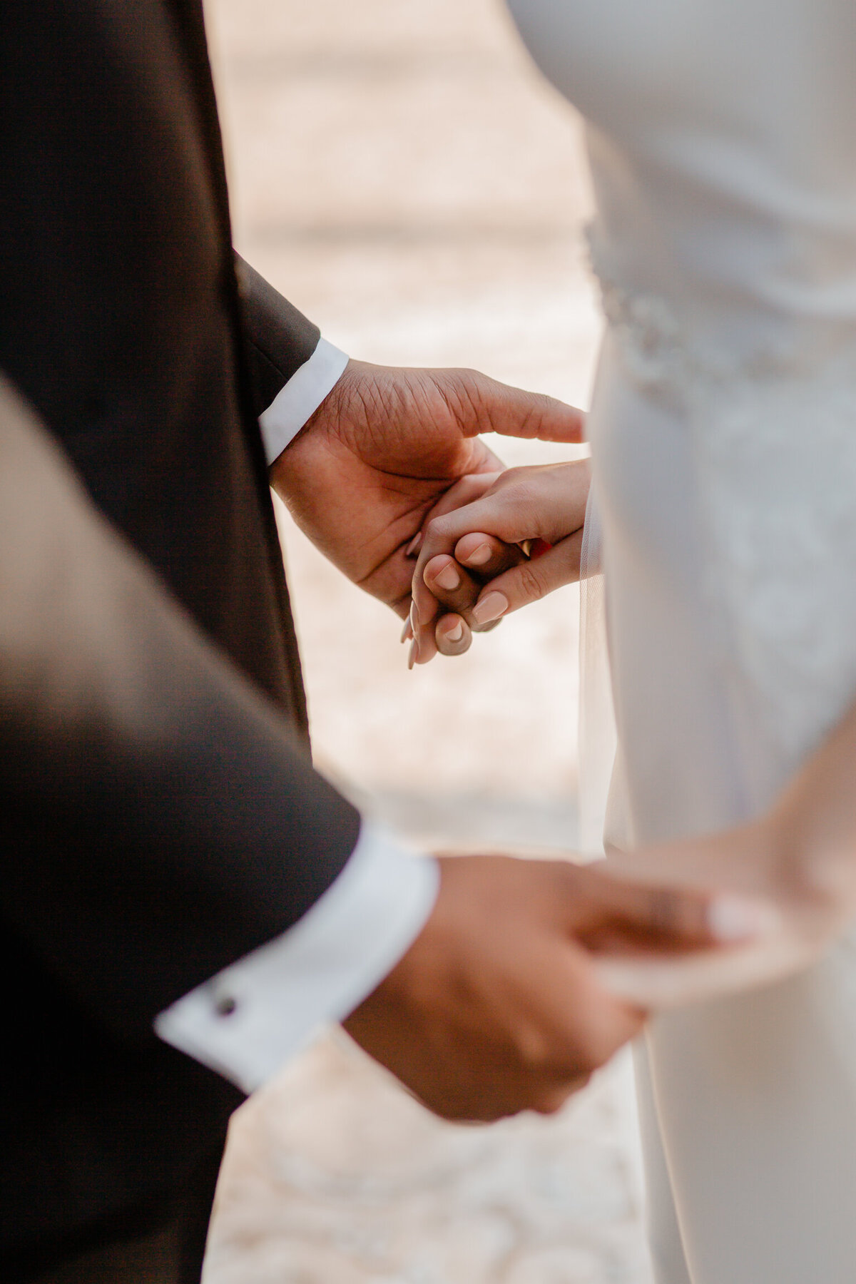 alt="bride and groom holding hands ceremony"