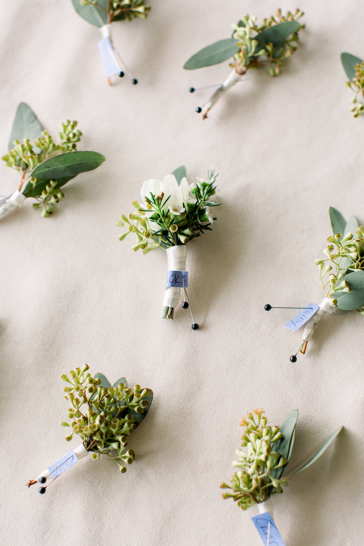 Groom and groomsmen boutonnieres pinned to board at Woodlands wedding in Colorado