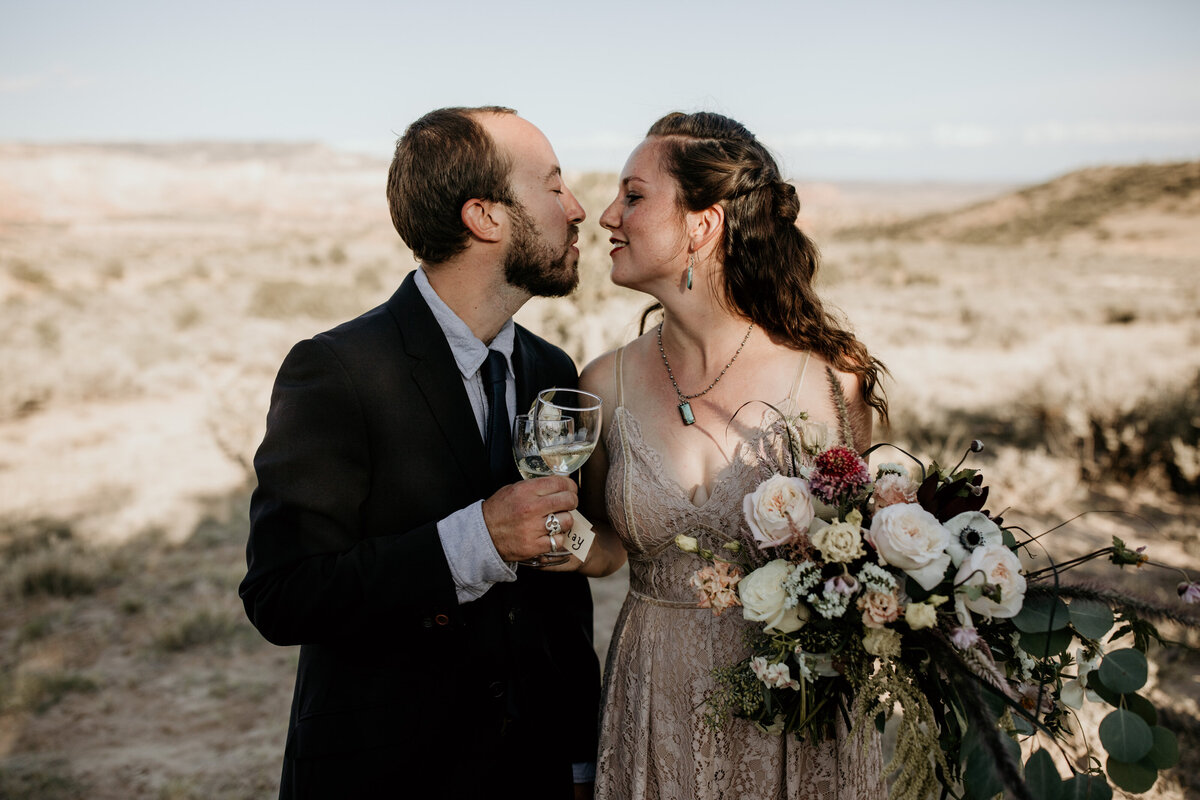 bride and groom about to kiss with champagne