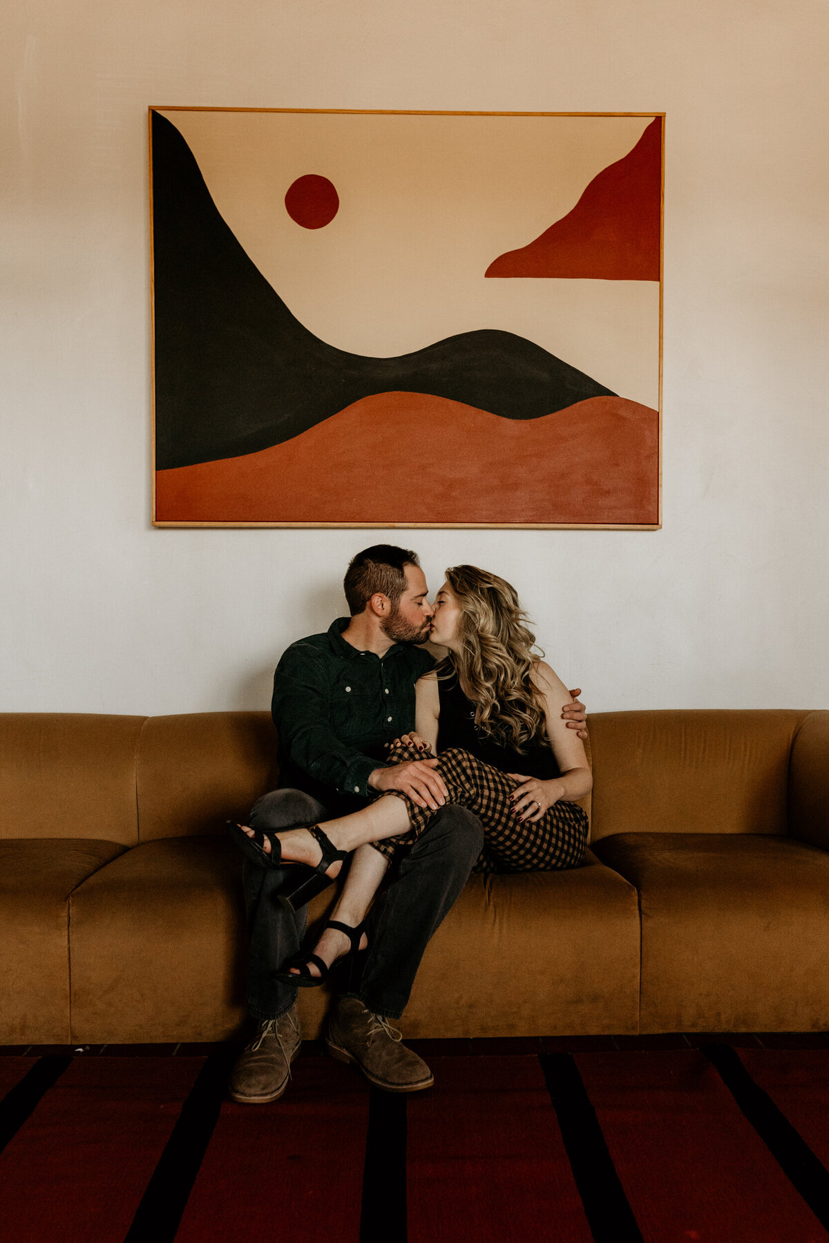 engaged couple sitting on a retro southwest couch together