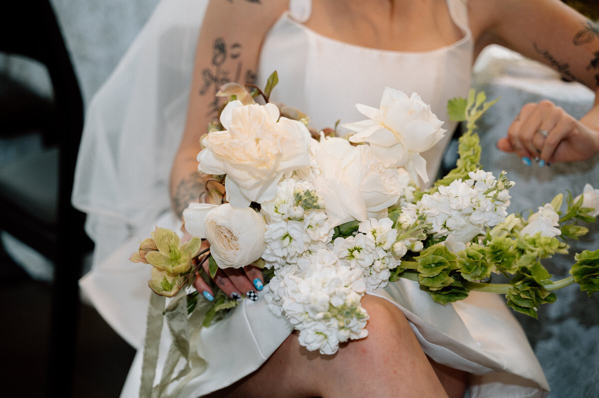 Close-up of neutral floral bouquet held by bride during relaxed wedding morning in Banff.
