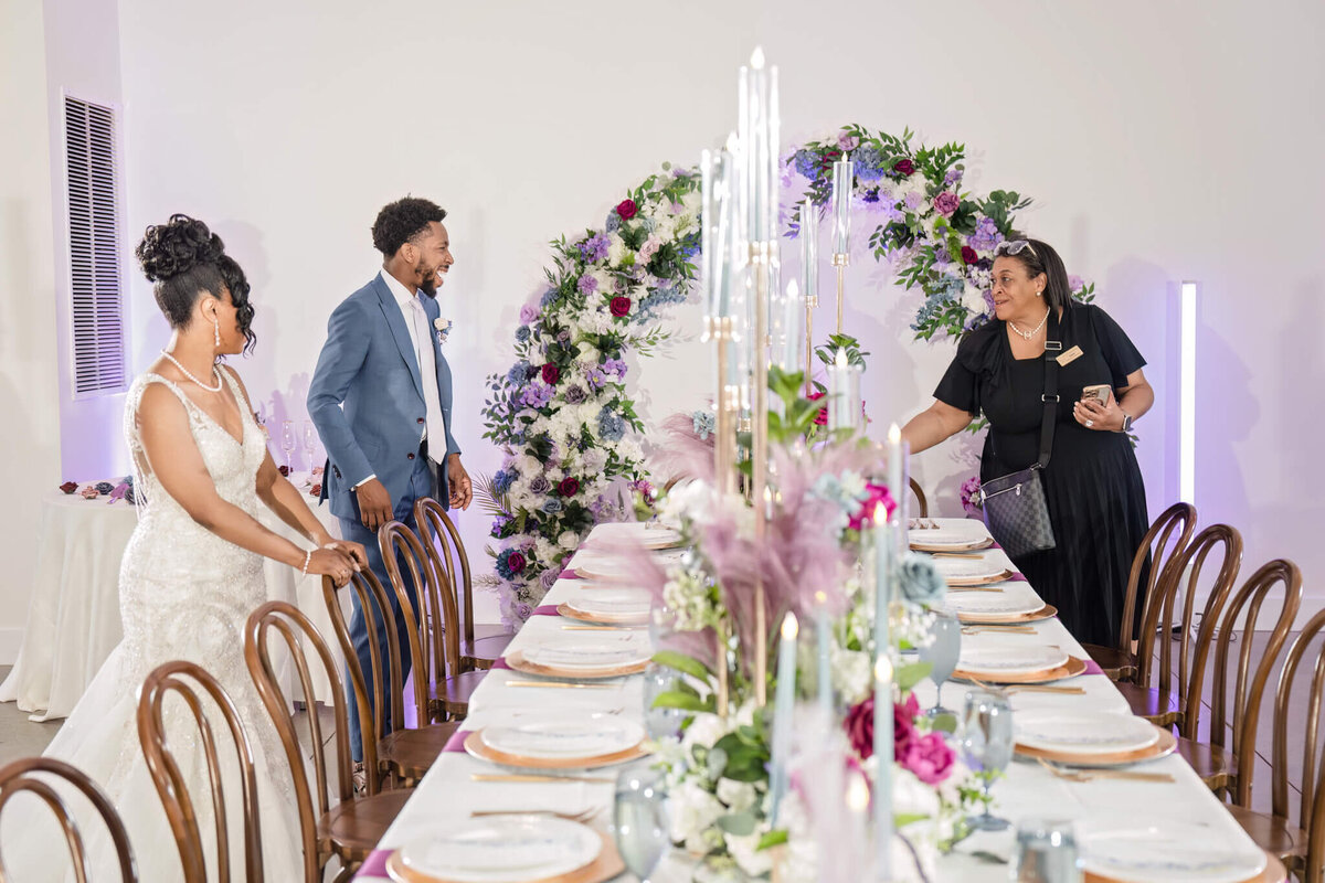 Luxury wedding planner adding final touches to an elegant reception table setup.
