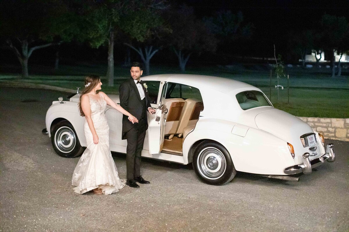 groom leads bride into Rolls Royce at Sendera Springs in Kerrville Texas