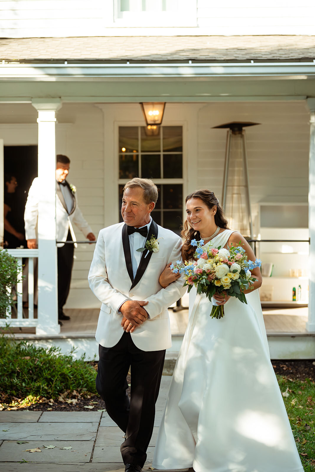 Bride arm in arm with her dad walking down the aisle