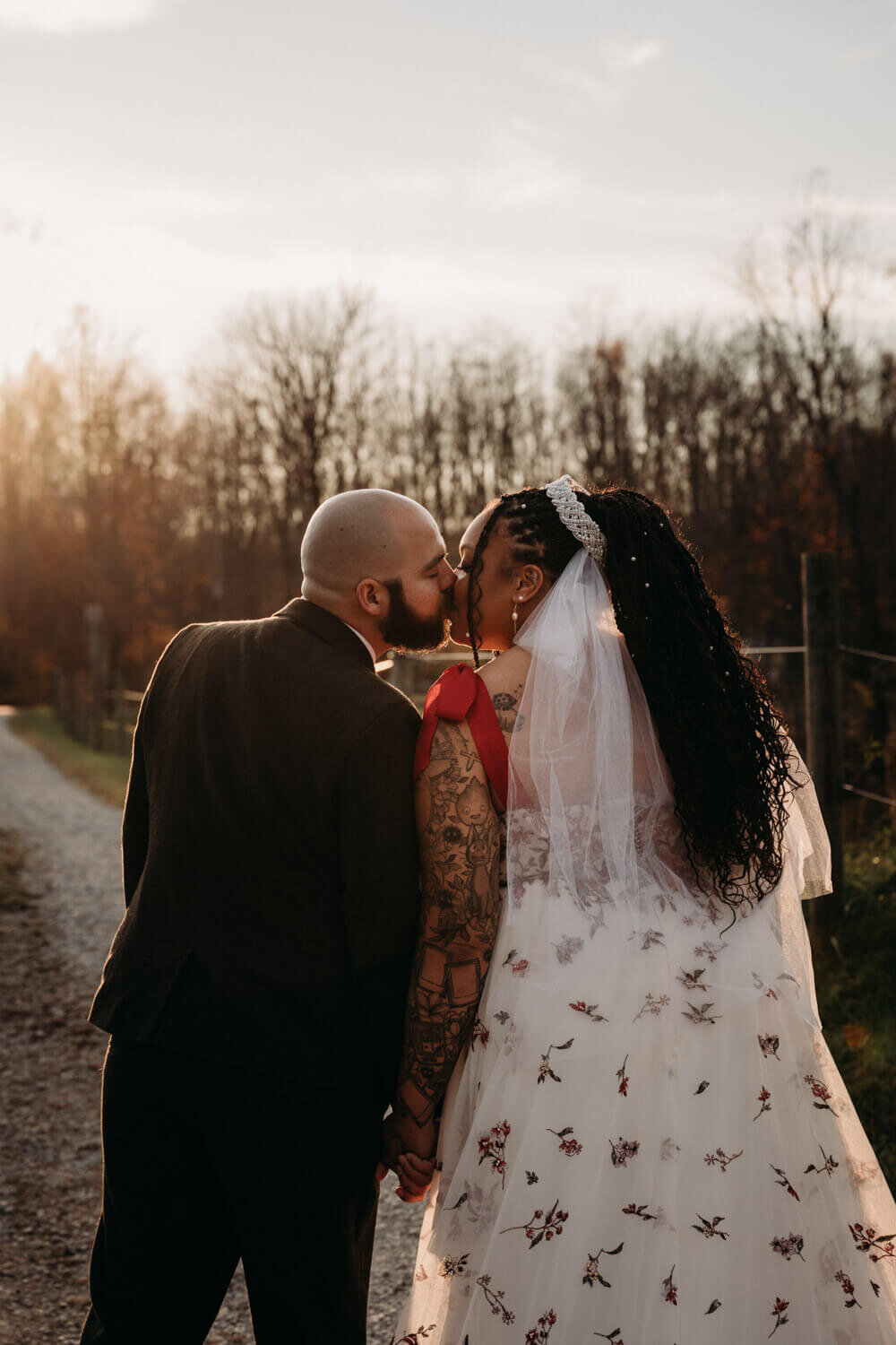 Newlyweds kiss at golden hour near horses
