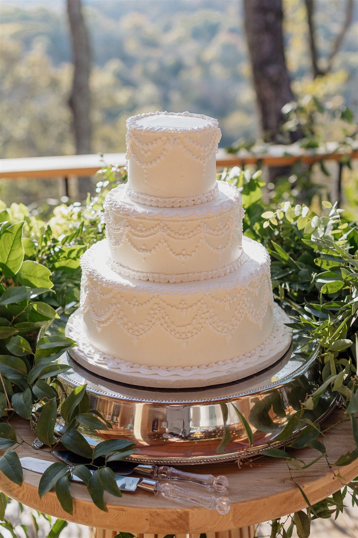 vintage white wedding cake  surrounded by greenery