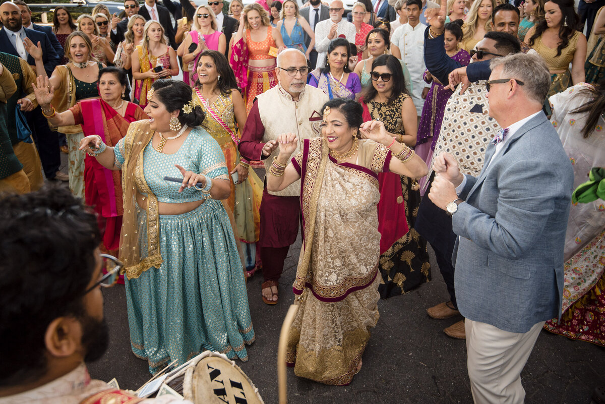 Indian wedding baraat celebration at Le Méridien Charlotte. Family and guests dressed in colorful lehengas, sarees, and suits dance joyfully to live dhol music. Captured by a Charlotte Indian wedding photographer specializing in vibrant, candid wedding moments full of energy and tradition.