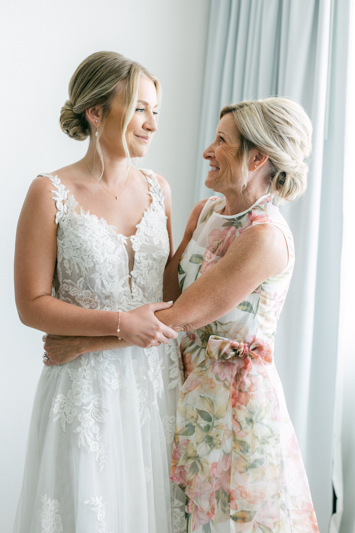 Bride and mom smiling and embracing before wedding ceremony in Cancun, captured by Philly wedding photographer.