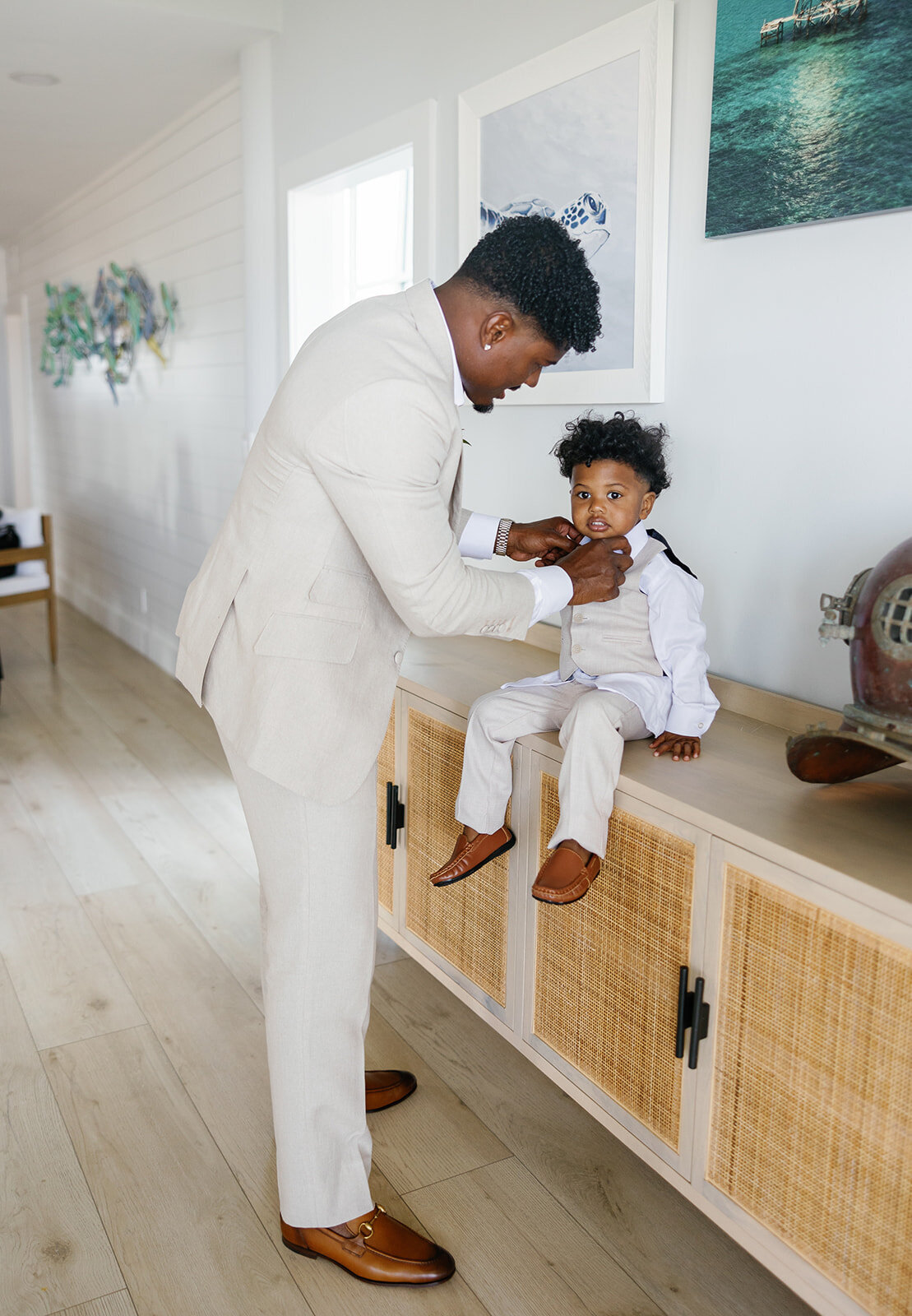 Groom Jonathan helps his young son adjust his bowtie before the wedding ceremony at Table Key, Islamorada. Captured by Claudia Amalia, destination wedding photographer.