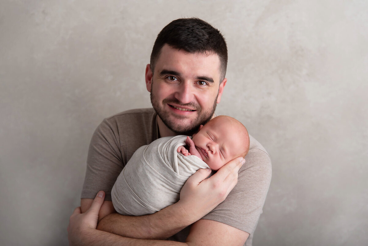 dad holding newborn baby boy for his newborn photography photos.