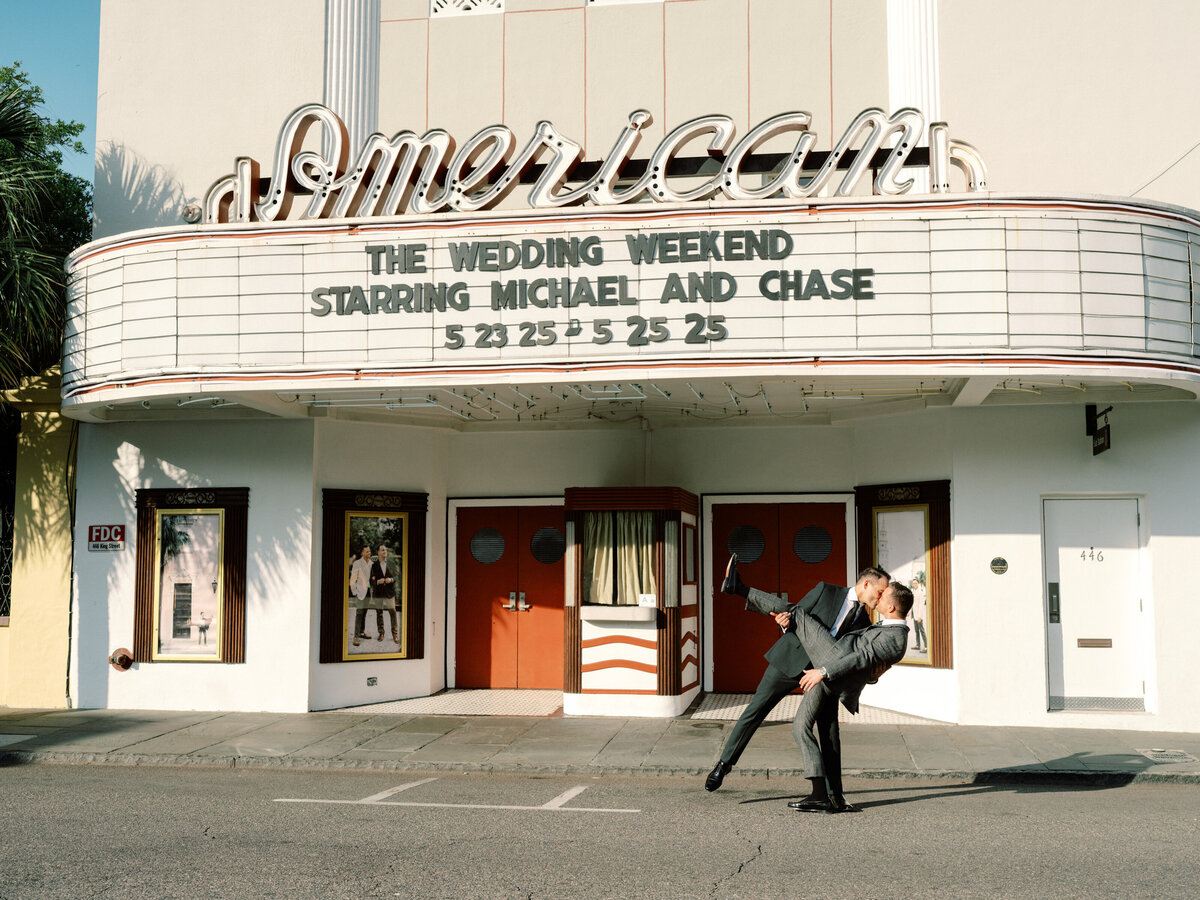 A stunning view of the American Theater displaying a wedding weekend announcement, featuring two grooms in suits, blending romance with a classic vintage touch.