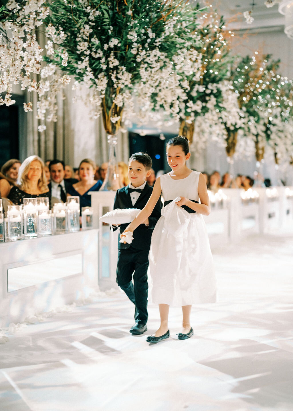A photo of the flower girl and ring bearer walking down the aisle. 