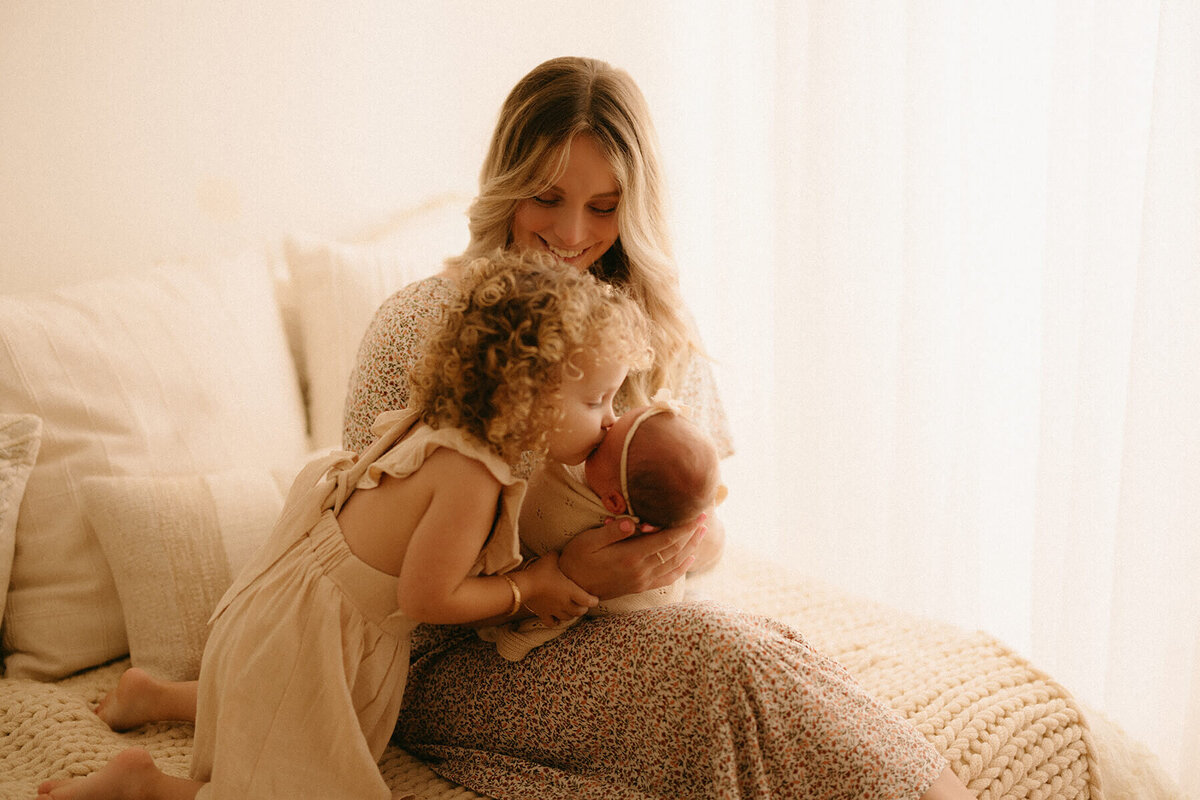 mom smiling down at newborn during professional studio session in Nashville TN