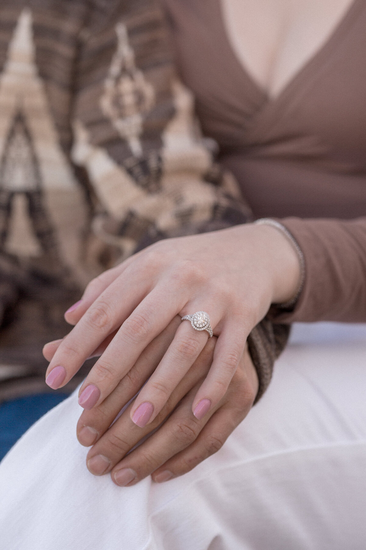 A detail photo featuring a halo engagement ring