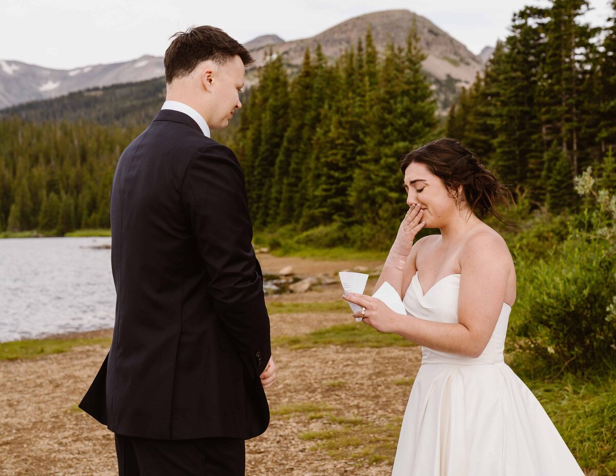 Bride reading emotional vows to groom during an intimate Brainard Lake Recreation Area elopement in the Colorado mountains.