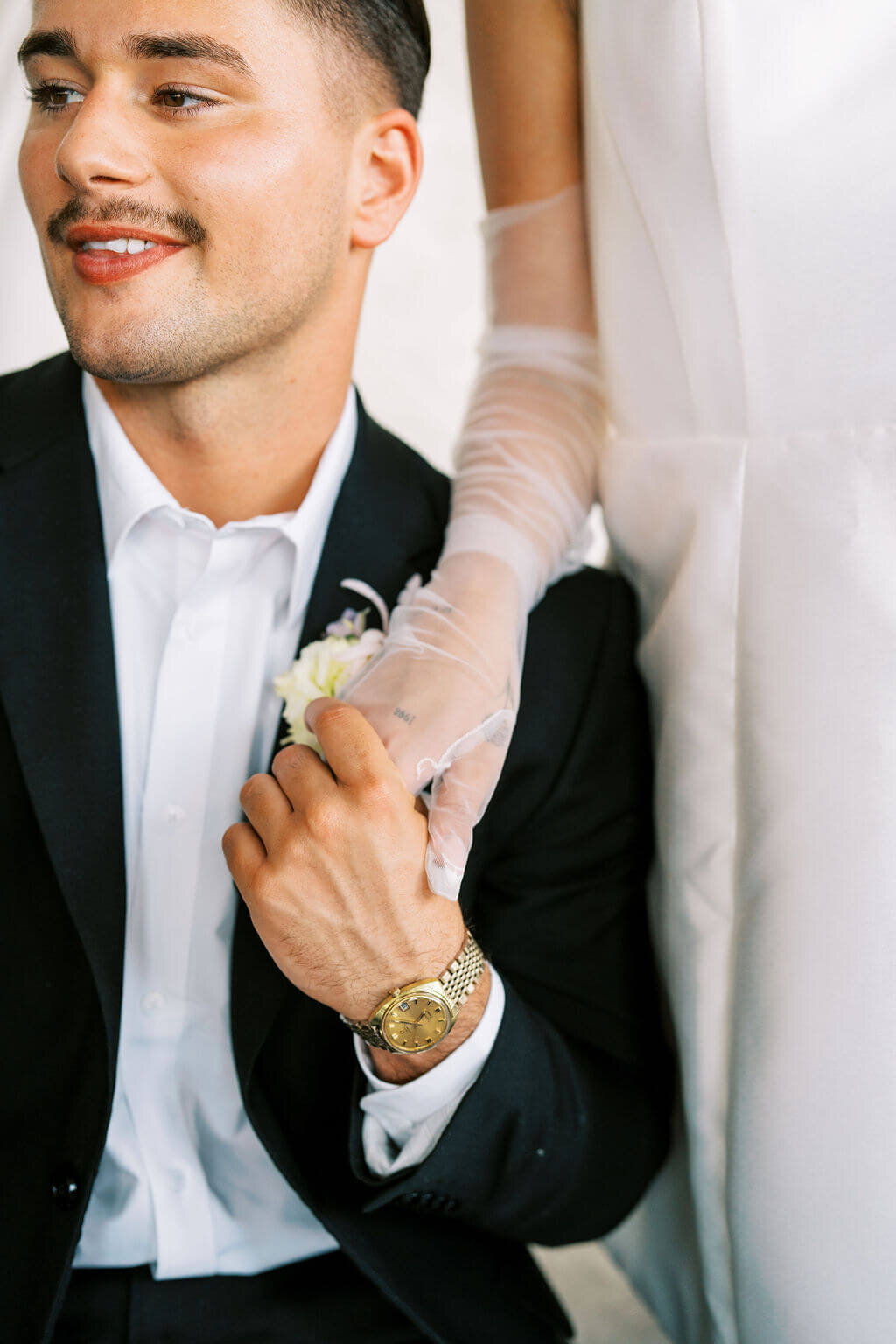 Detail picture of a couple holding hands on their wedding day