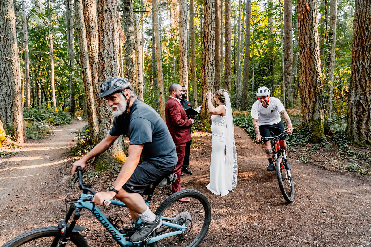 a happy, laughing bride and groom as bike riders ride through their ceremony