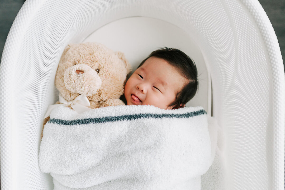 Newborn with teddy sticking his tongue out by Denise Van, a Northern VA newborn photographer