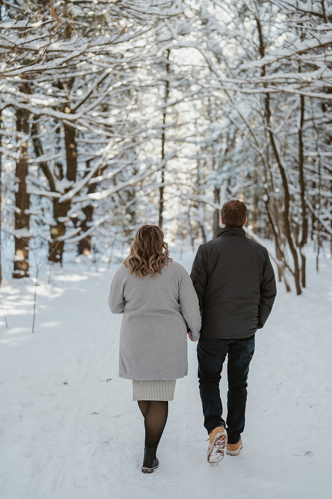 Close-up of expecting parents holding the pregnant belly during their winter maternity session at Al Sabo Preserve in Kalamazoo Michigan.