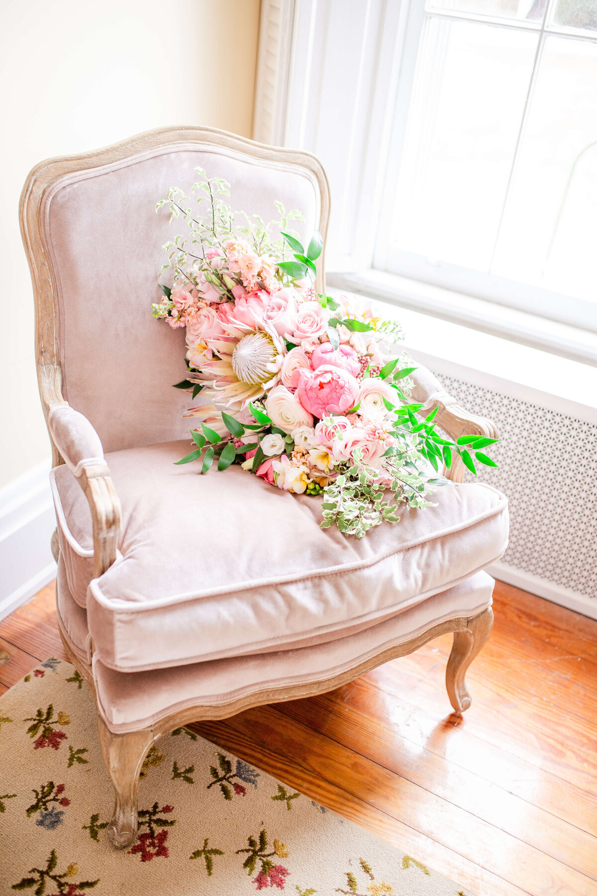 Pink-bridal-bouquet-on-elegant-chair-near-window-wedding