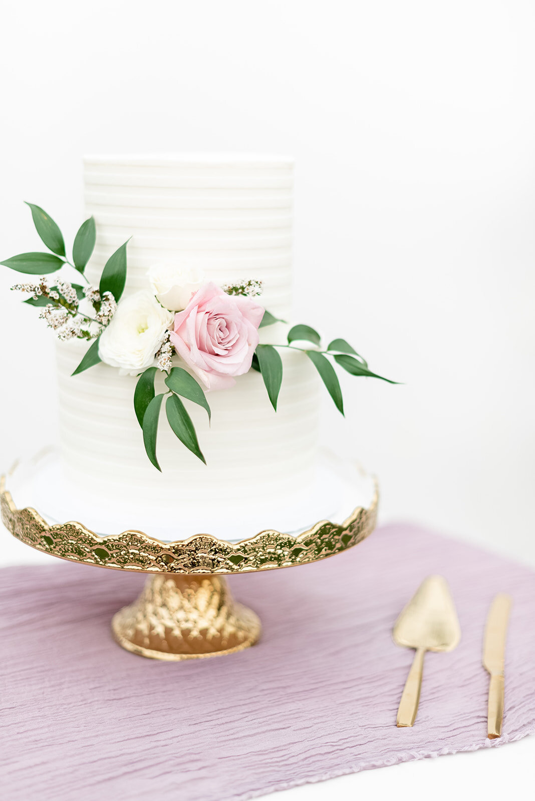 White wedding cake on antique gold cake stand, Light and airy wedding photography by the Best Boise Wedding Photographers