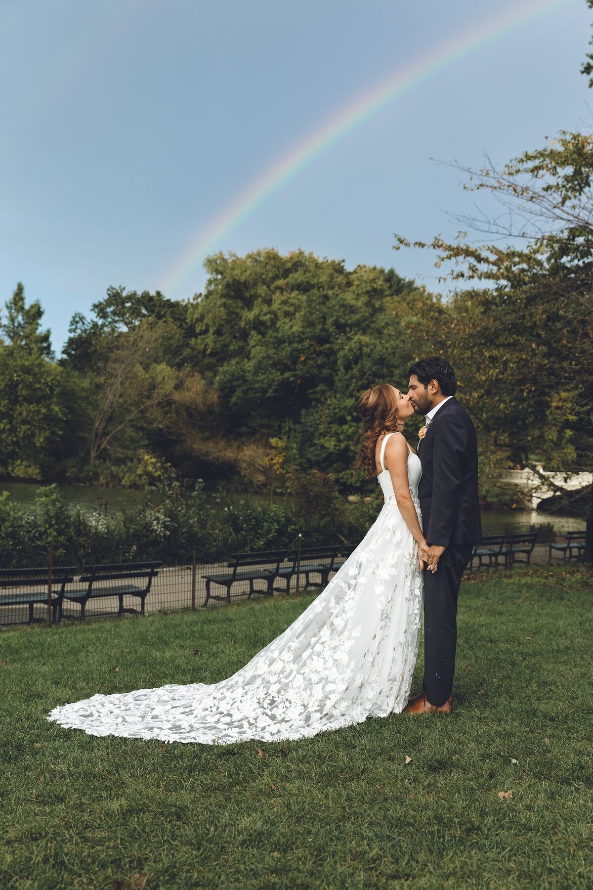Bride and groom celebrating under a rainbow in Central Park