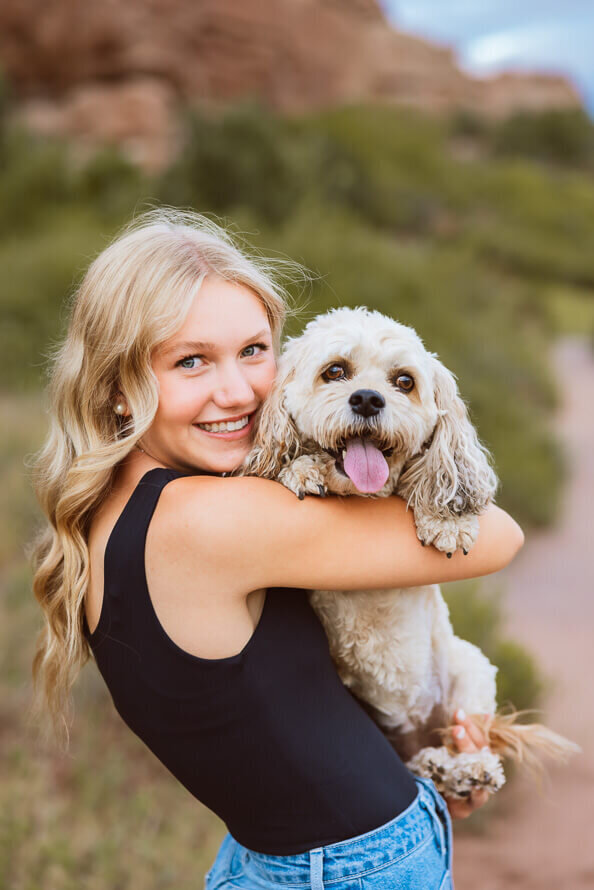 Girl holds dog with his tongue out.