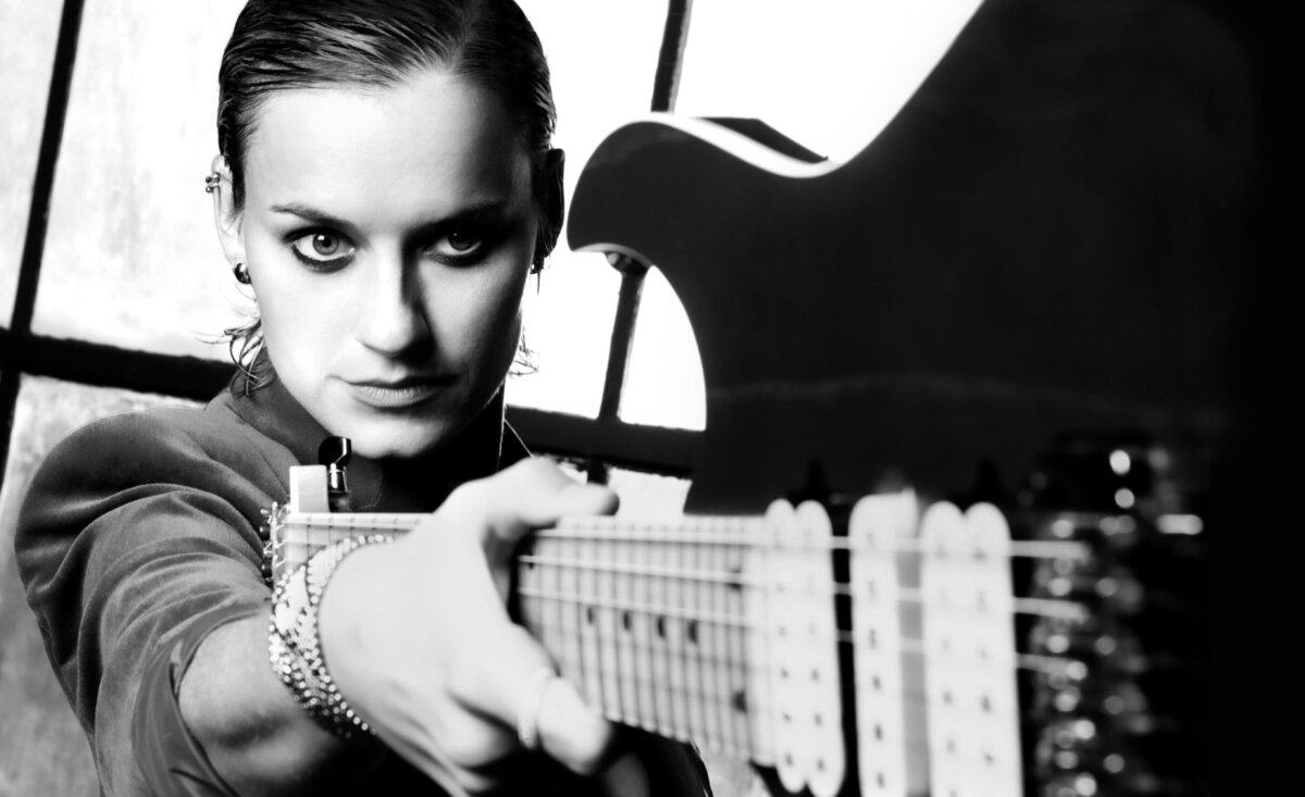 Female musician portrait black and white close up Yasi Hofer holding outstretched electric guitar