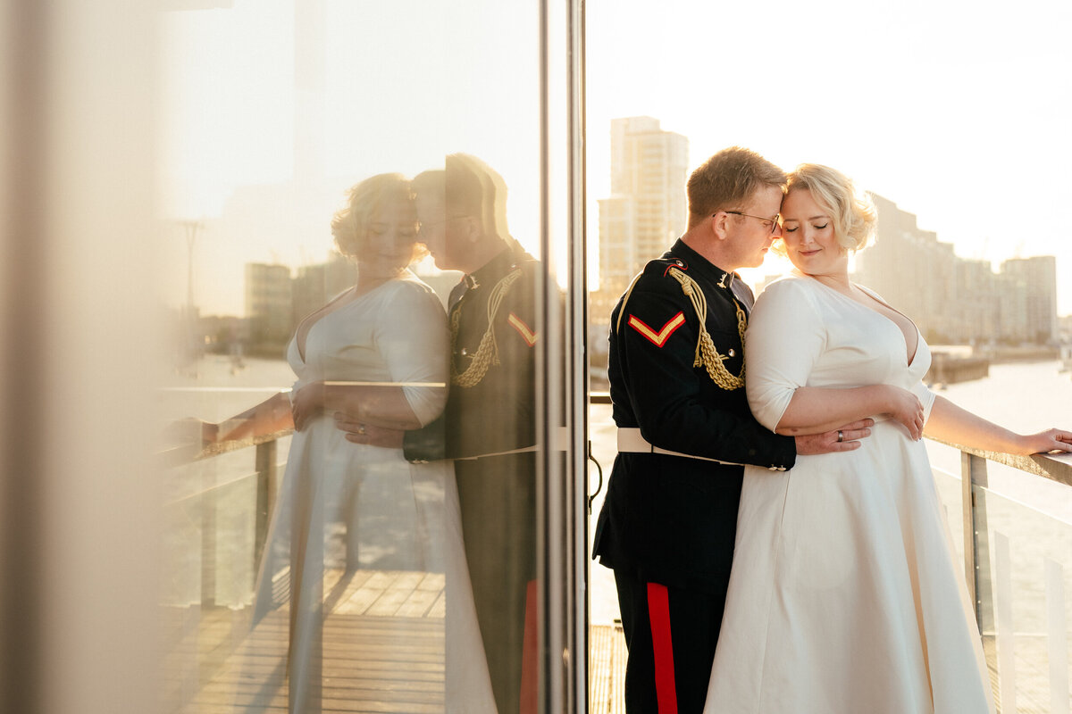 A bride and groom embrace during golden hour on their wedding day.