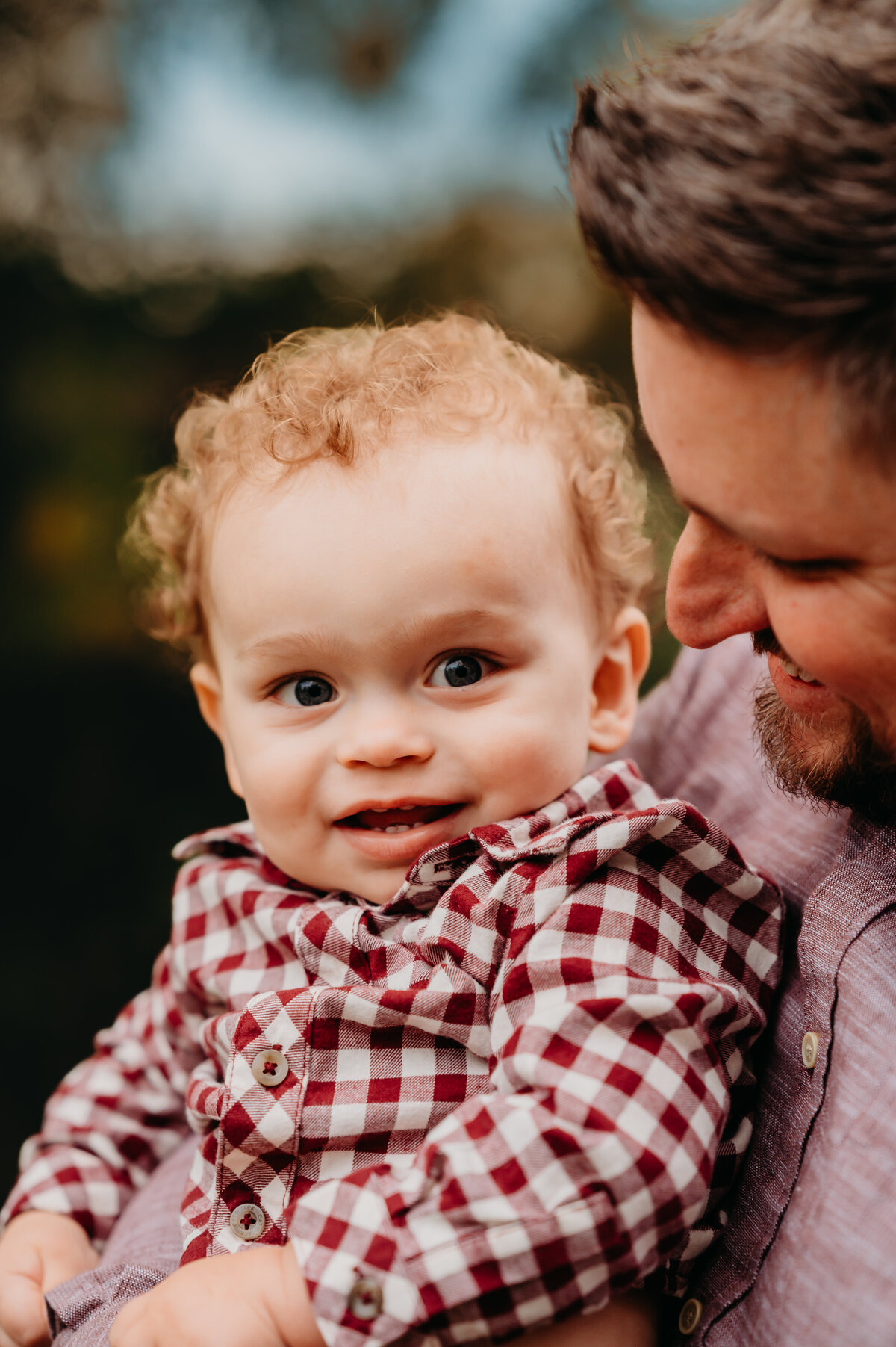 Baby smiling while being held by a parent outdoors — tender family photography in Aledo by Poppy + Blue Photography