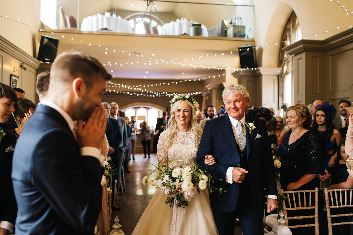 An emotional groom as his bride walks down the aisle at Ellingham Hall