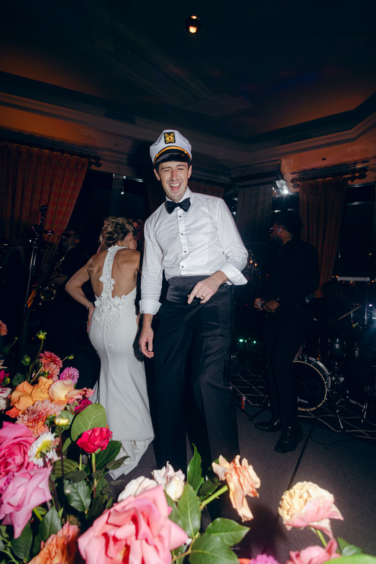 A wedding photo of the bride and groom during a candid moment during their wedding reception