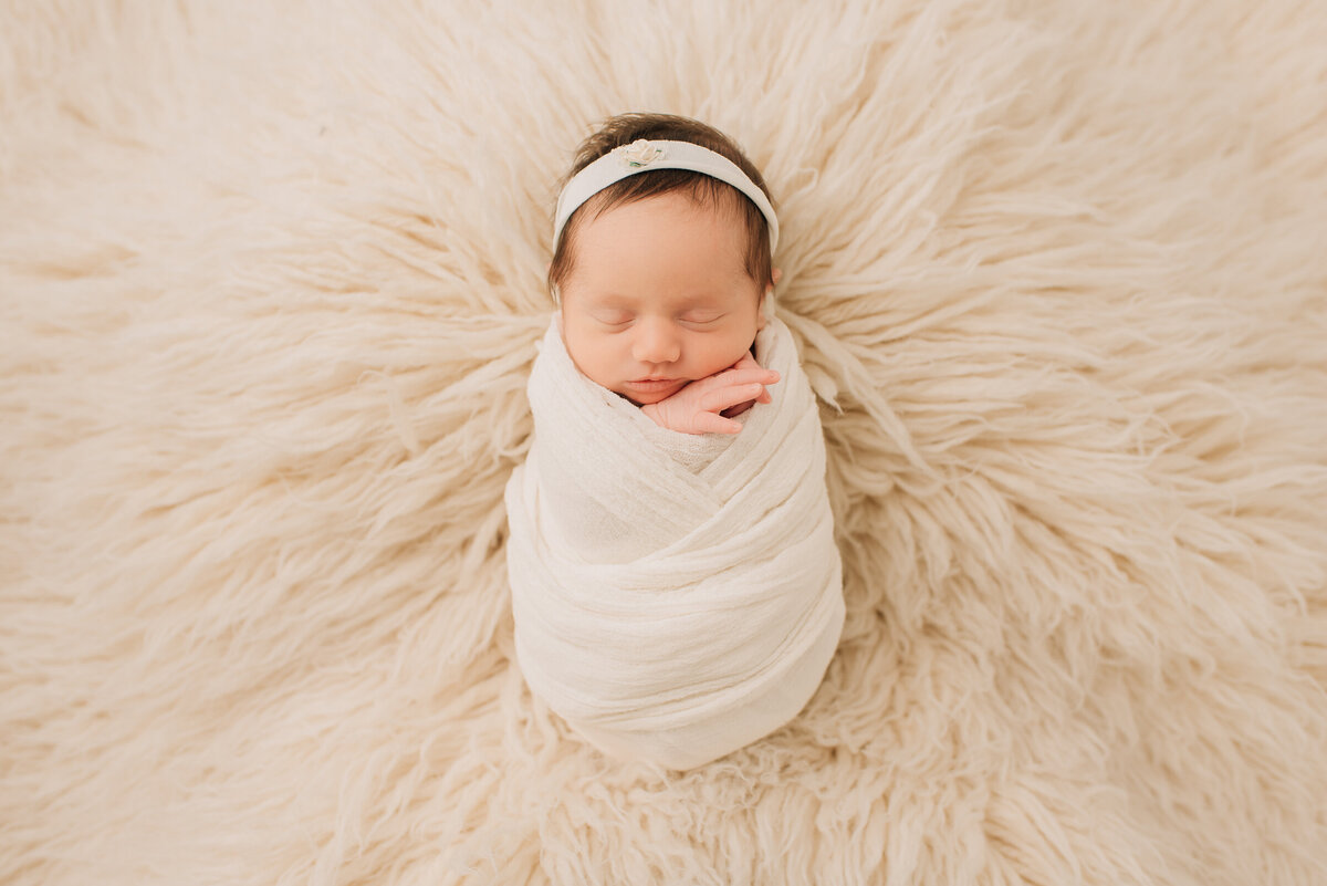 A young girl wrapped in white at her newborn session with Sharon Leger Photography in Canton, CT.
