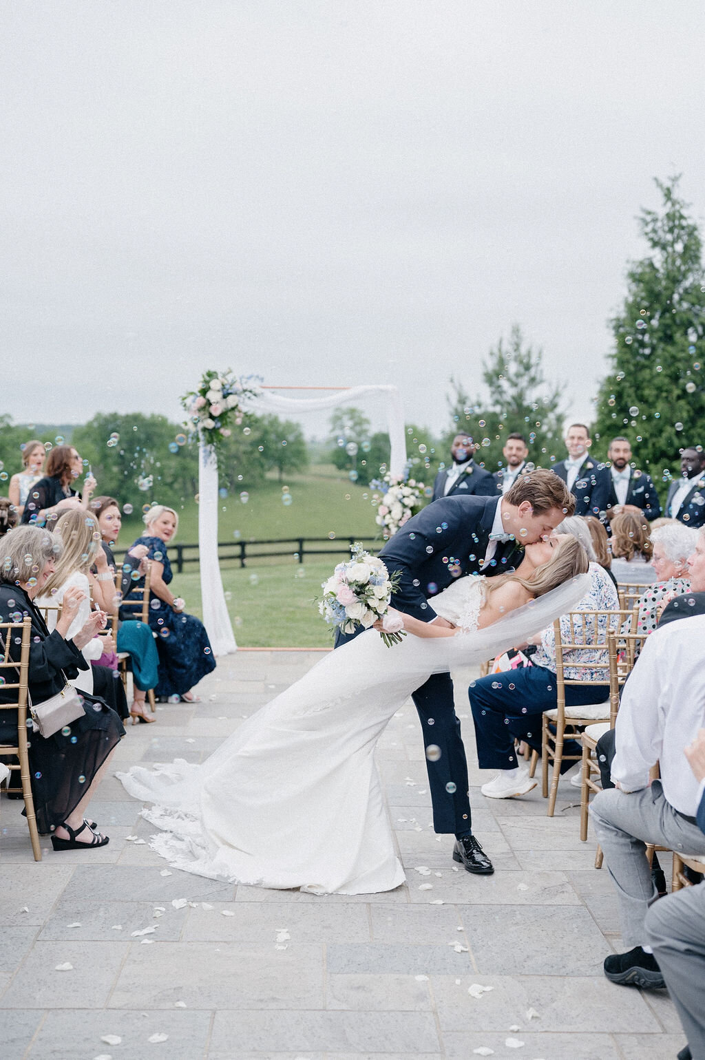 Bride and groom's deep kiss after their wedding ceremony with bubbles