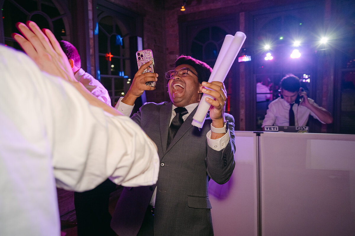 Guests laughing and dancing in courtyard at The Battalion wedding party