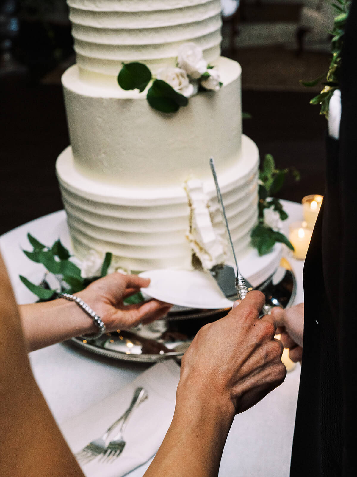 41. closeup-wedding-cake-cutting-white-frosting-greenery-roses