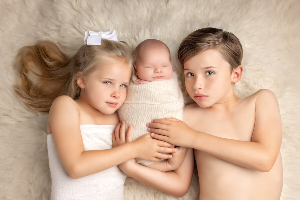 siblings photographed with newborn baby in summverville sc photography studio