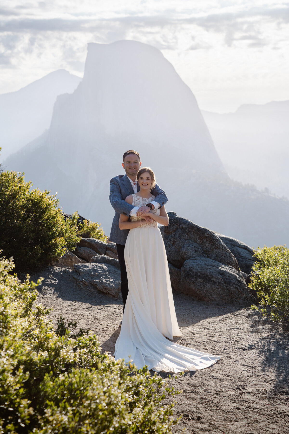 A person standing behind their partner with their arms around them