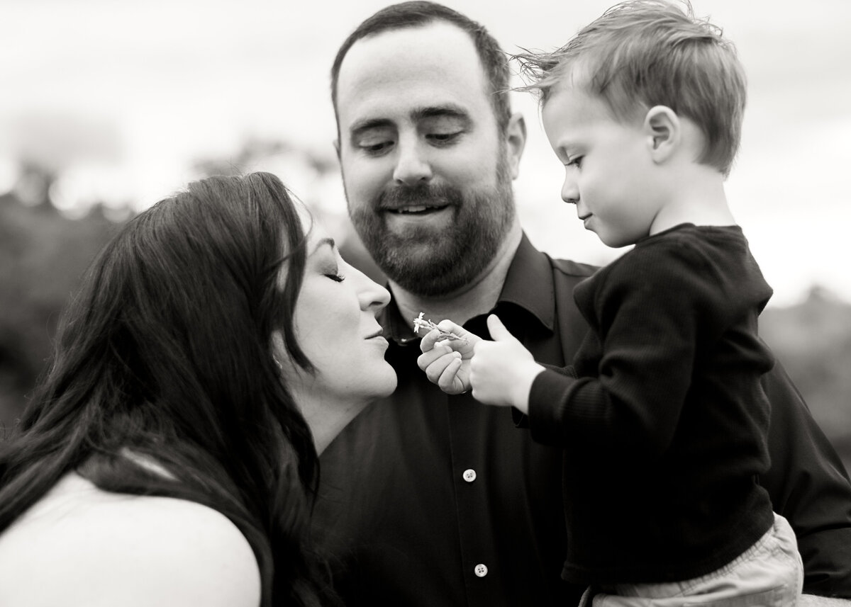 Lifestyle family photoshoot in Colorado of mother smelling a flower in Black and white