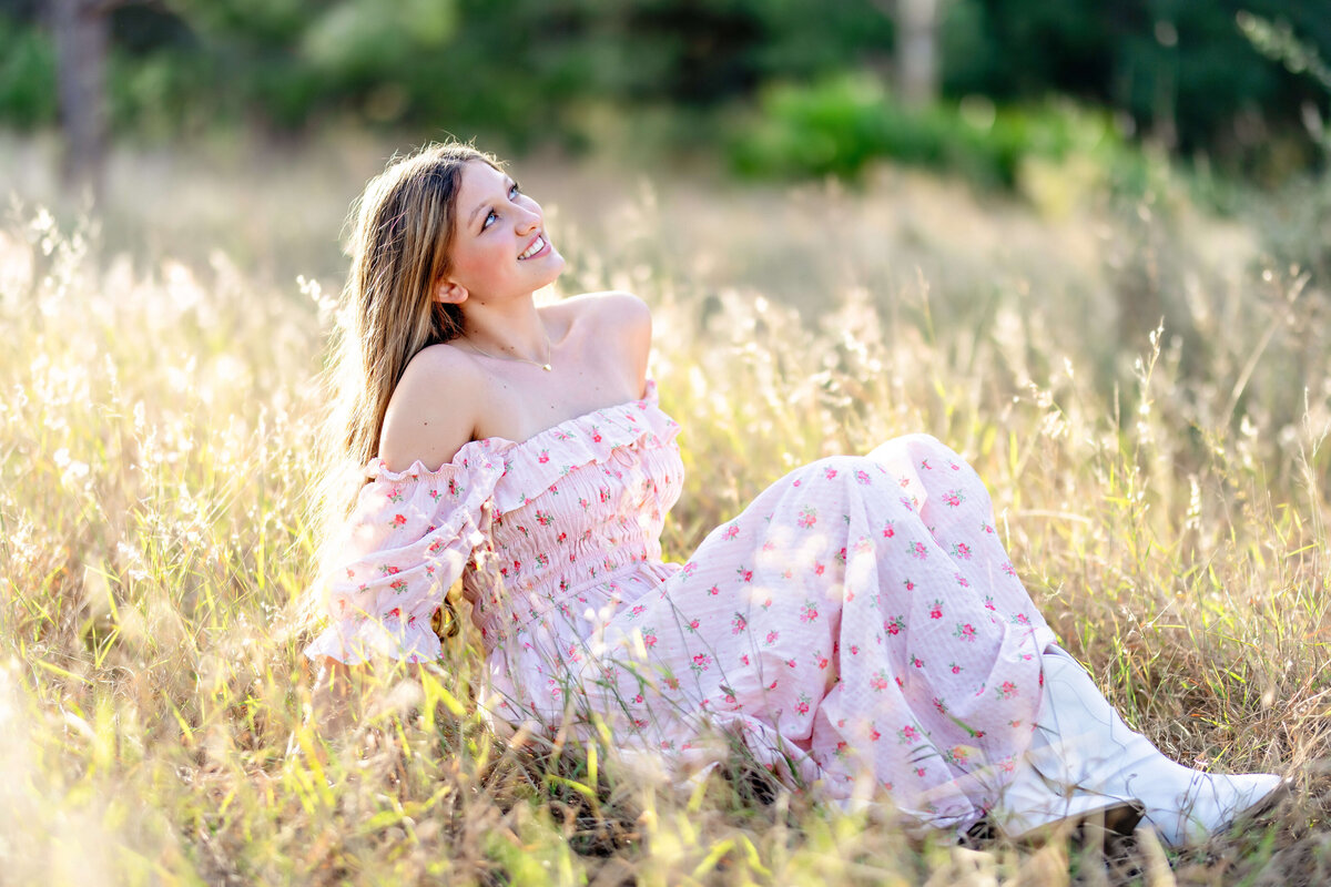 Golden hour glow on senior girl sitting in a field in Windermere, Florida
