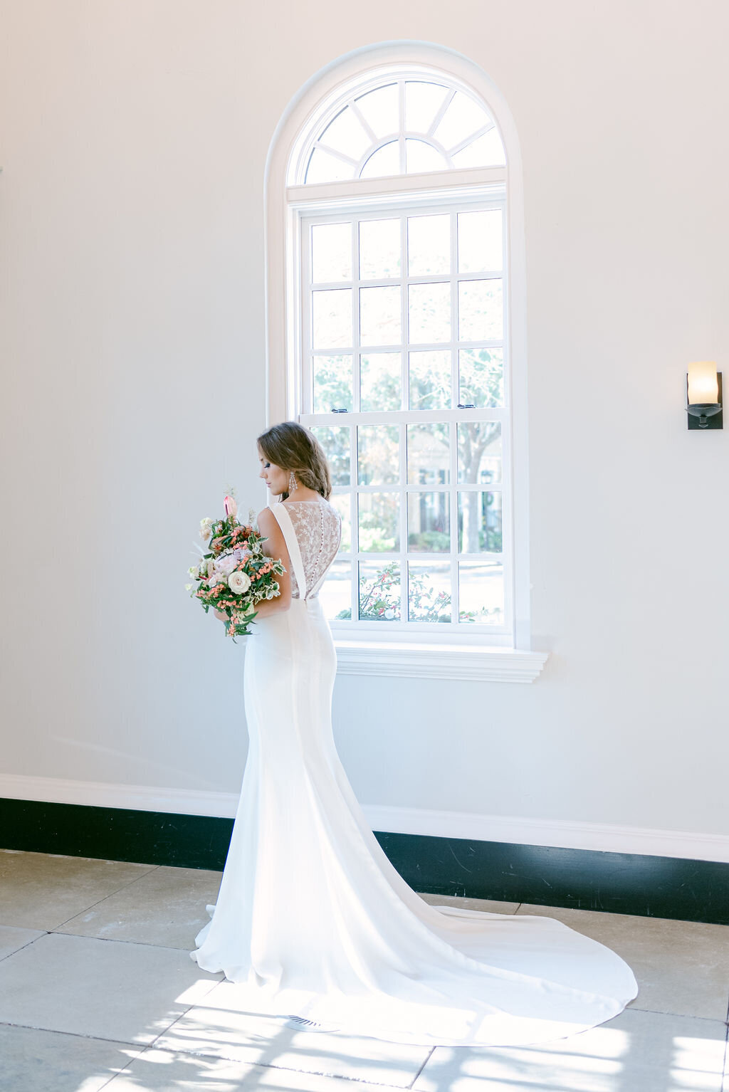 This fit-and-flare wedding gown by Edith Elan features a crepe chapel-length train.