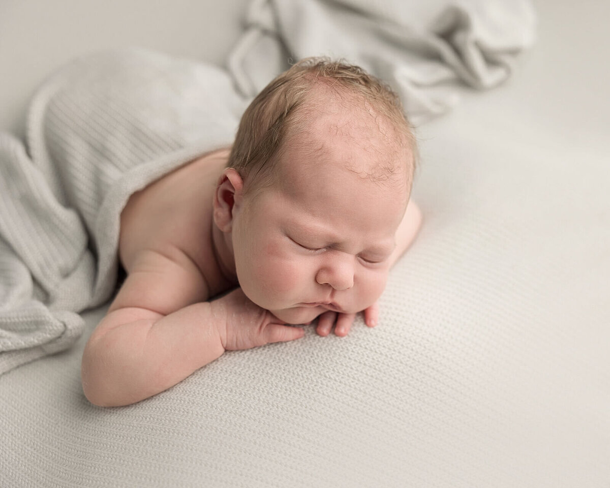 baby boy on grey blanket for newborn pictures
