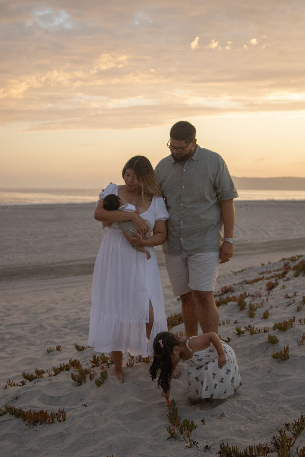 Family enjoying a quiet moment on the beach, with their children