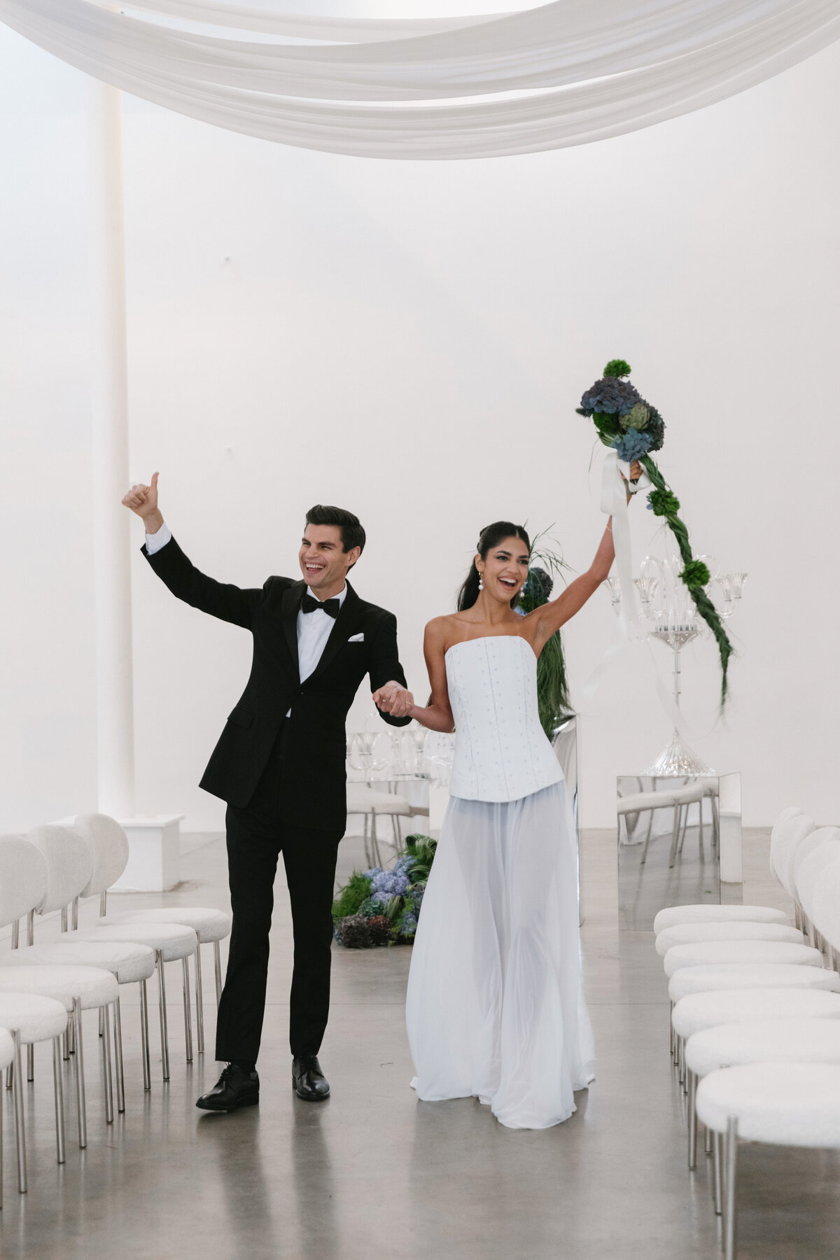 Close-up portrait of bride and groom embracing during an editorial wedding shoot in a bright white NYC studio.